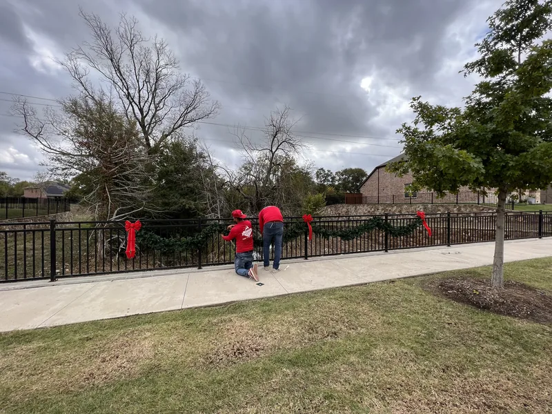 Commercial Christmas light installation DFW — professional crew installing holiday lighting and garland