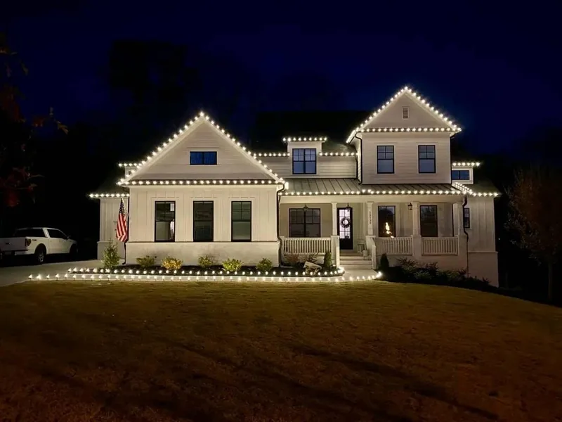Christmas light installation by Christmas Lights Experts DFW &mdash; modern farmhouse with a warm white roofline outlining every peak and porch line