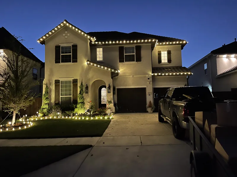 Christmas light installation Frisco TX — warm white roofline and landscape lighting on a stucco home