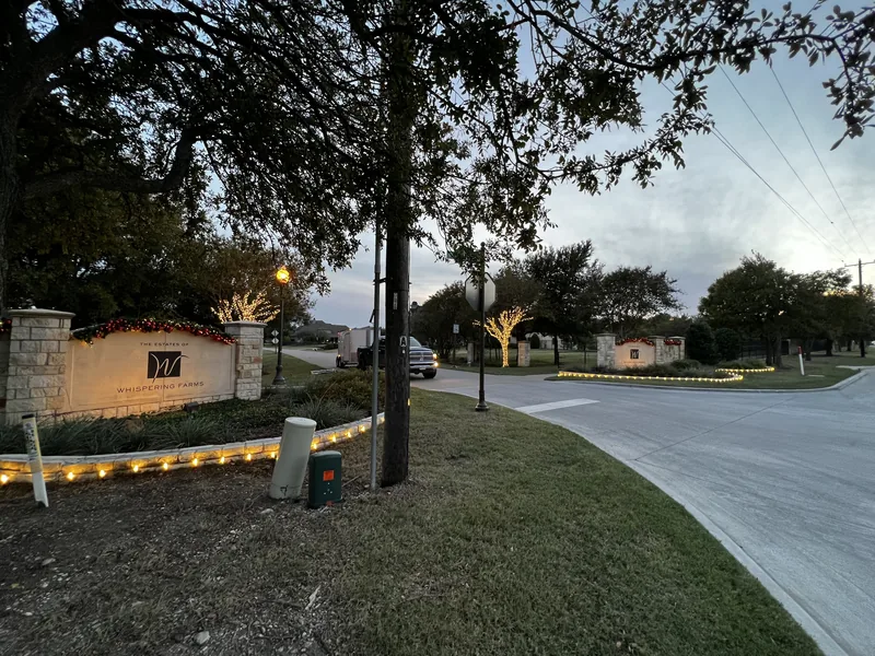 HOA Christmas light installation DFW — holiday lighting on a community monument sign