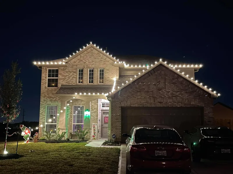 Christmas light installation Lewisville TX — multicolor roofline and lit arches on a brick home